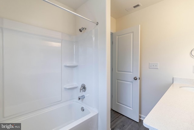 bathroom featuring hardwood / wood-style floors, vanity, and shower / washtub combination