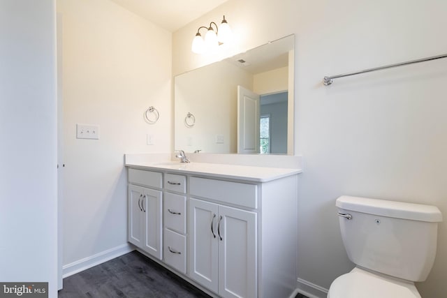 bathroom with vanity, hardwood / wood-style flooring, and toilet