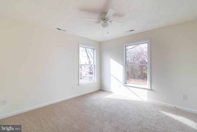 carpeted empty room featuring a textured ceiling and ceiling fan