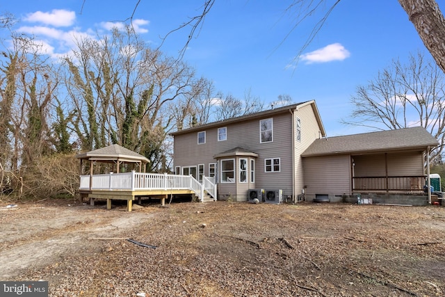 rear view of property featuring a gazebo and a deck