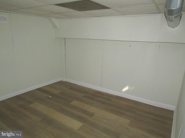 basement with a paneled ceiling and dark hardwood / wood-style floors