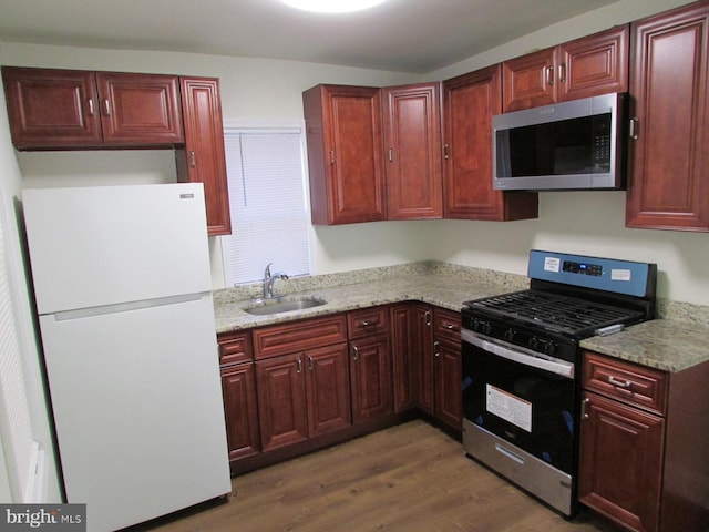 kitchen featuring light stone countertops, stainless steel appliances, sink, and dark hardwood / wood-style flooring