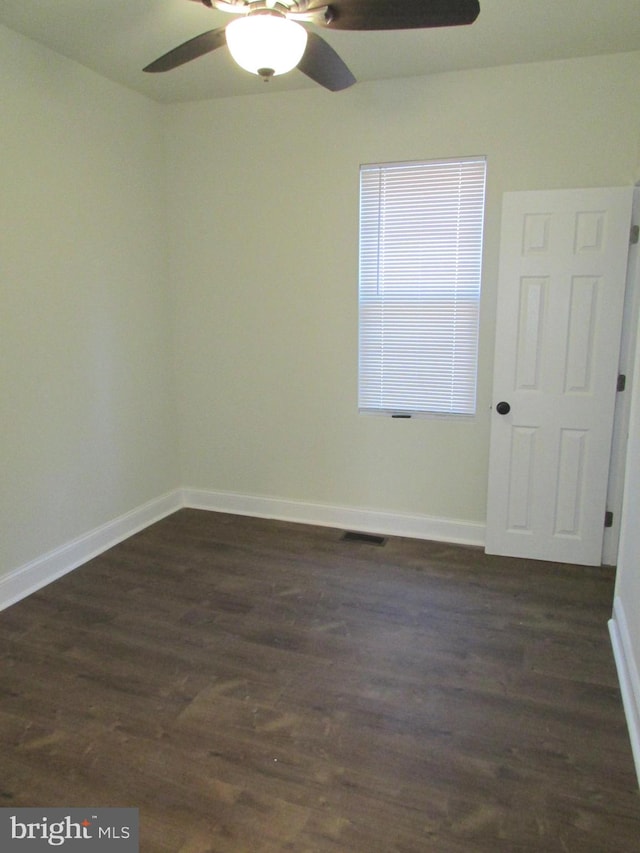 unfurnished room featuring dark wood-type flooring and ceiling fan