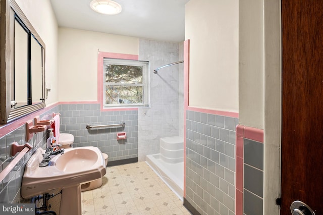 bathroom with walk in shower, toilet, and tile walls