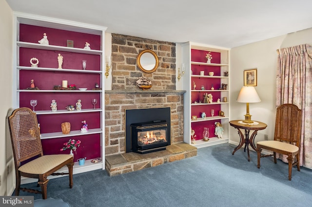 sitting room with carpet flooring, a wood stove, and built in shelves