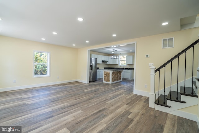 unfurnished living room featuring sink and light hardwood / wood-style flooring