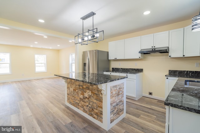 kitchen featuring light hardwood / wood-style floors, white cabinetry, stainless steel refrigerator with ice dispenser, a kitchen island, and pendant lighting