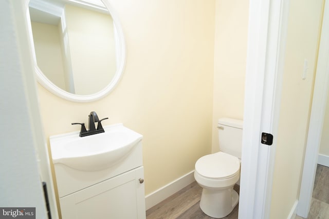 bathroom featuring hardwood / wood-style flooring, vanity, and toilet