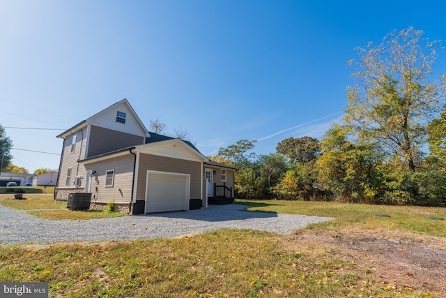 view of property exterior featuring central air condition unit, a lawn, and a garage