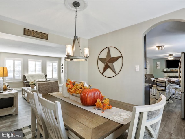 dining area with wood-type flooring and an inviting chandelier