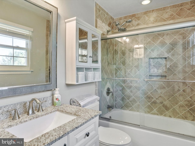 full bathroom with vanity, combined bath / shower with glass door, and toilet