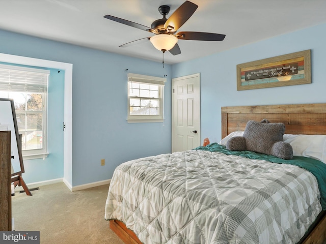 carpeted bedroom featuring ceiling fan and multiple windows