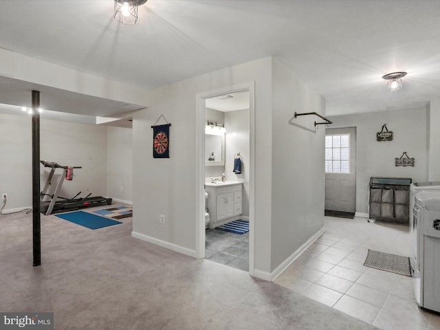 interior space featuring light colored carpet, sink, and separate washer and dryer