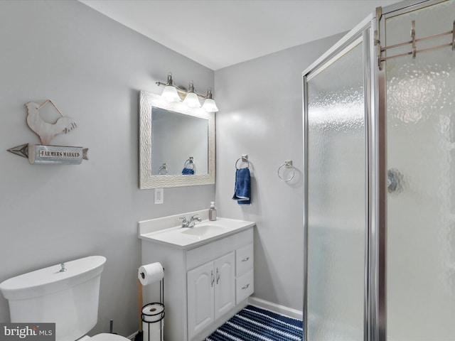 bathroom featuring vanity, toilet, and a shower with door