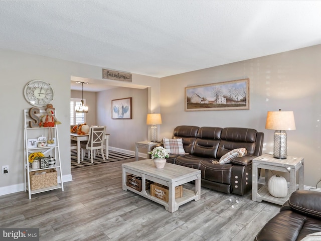 living room featuring a textured ceiling, hardwood / wood-style flooring, and a chandelier