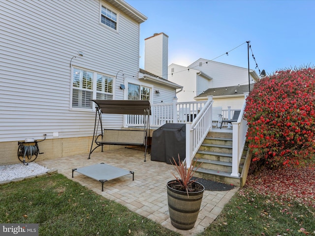 rear view of property featuring a deck and a patio area