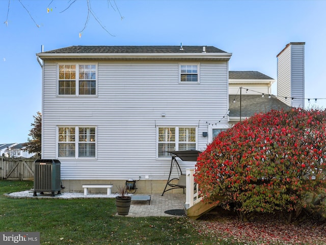 back of property featuring a patio area, central AC, and a lawn