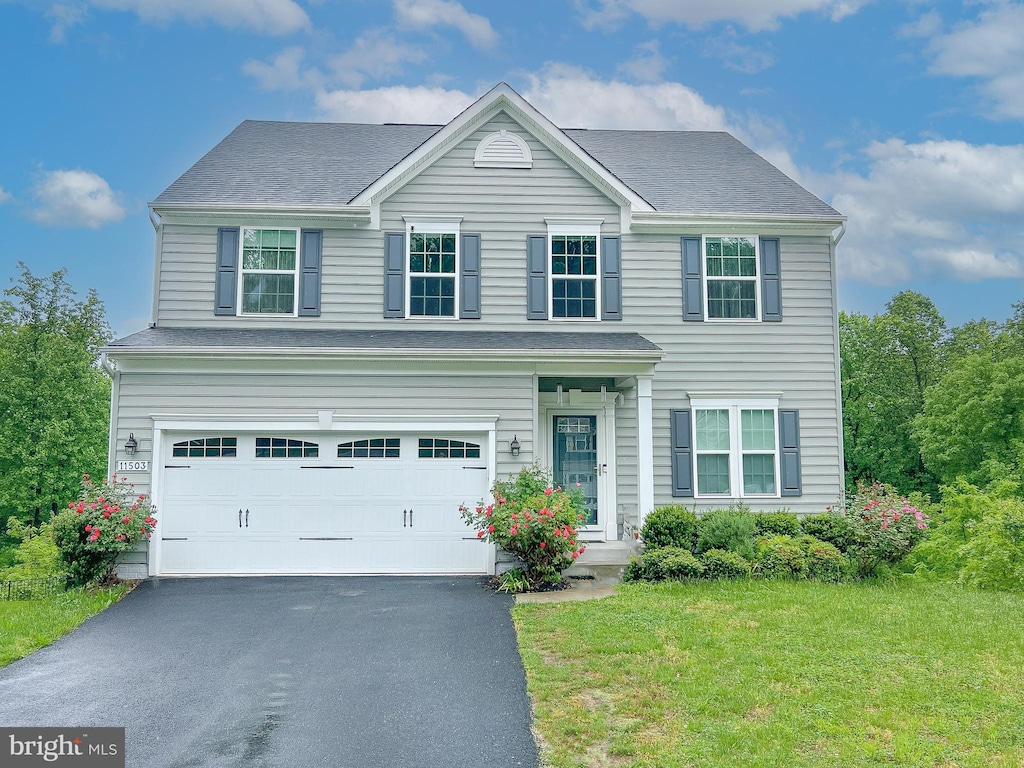 view of front of home with a garage and a front yard