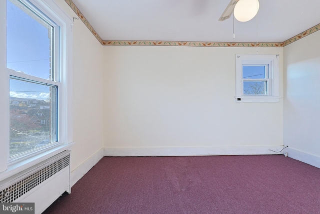 unfurnished room with carpet, ceiling fan, and radiator