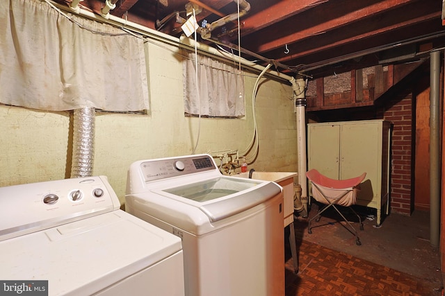 laundry room with parquet flooring and independent washer and dryer