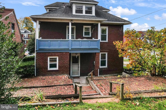 view of front property featuring a balcony and a patio