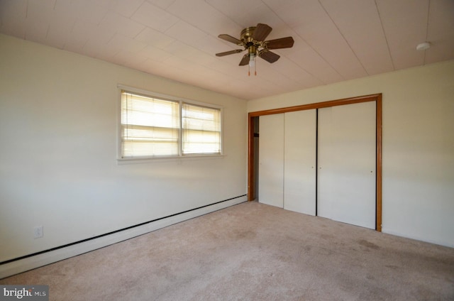 unfurnished bedroom with baseboard heating, light carpet, ceiling fan, and a closet