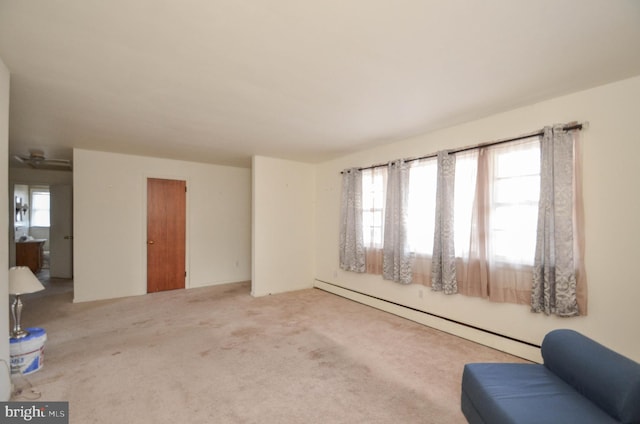 interior space featuring a baseboard heating unit and carpet flooring