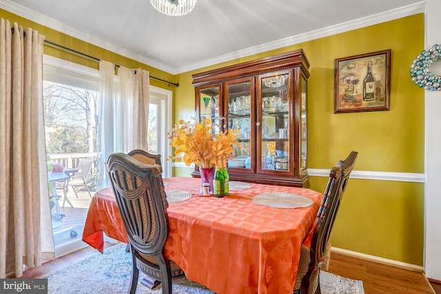 dining room with hardwood / wood-style flooring and ornamental molding