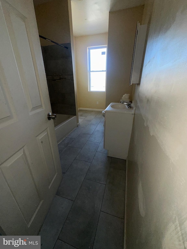 bathroom with tile patterned flooring, vanity, and tiled shower / bath