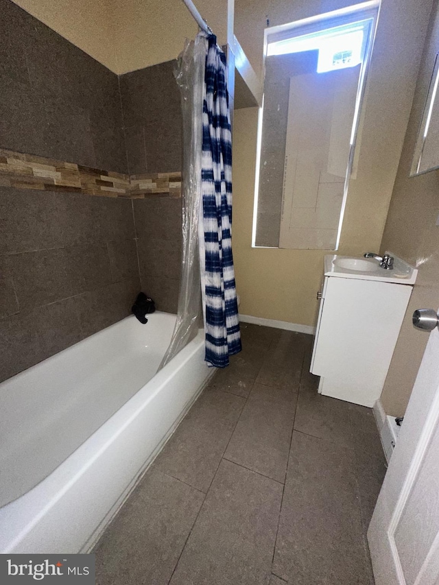 bathroom with tile patterned flooring, shower / bath combo with shower curtain, and sink