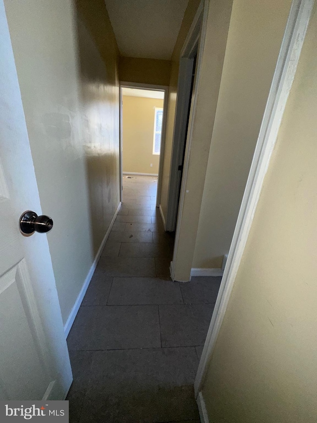 corridor featuring dark tile patterned flooring