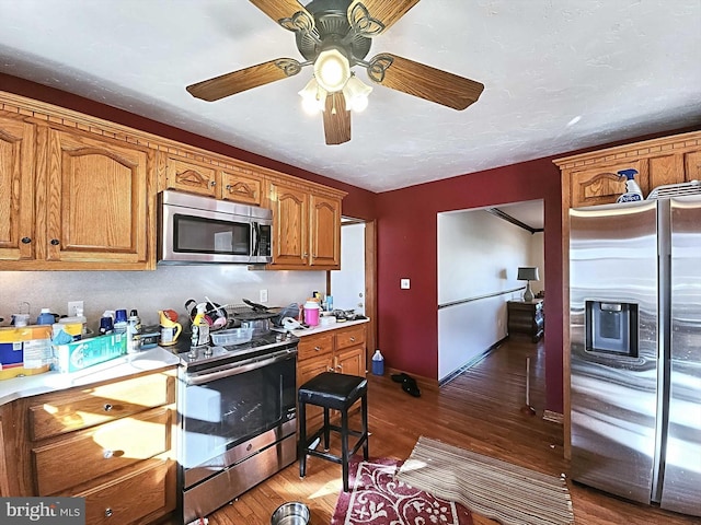 kitchen featuring ceiling fan, dark hardwood / wood-style flooring, and stainless steel appliances