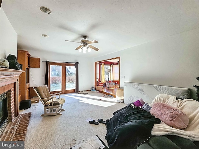 living room featuring light carpet, a brick fireplace, and ceiling fan