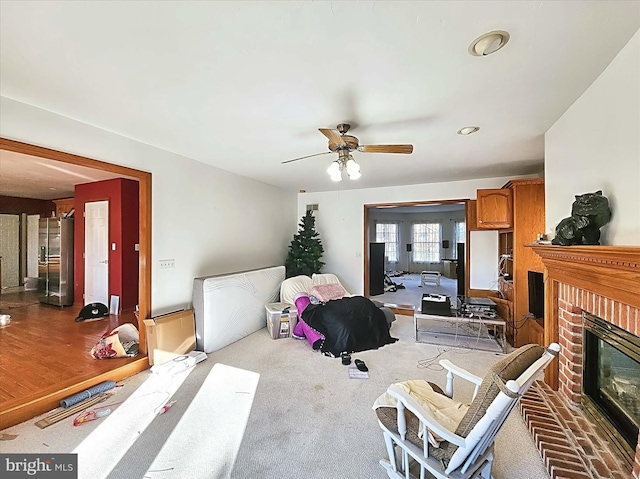 living room with hardwood / wood-style floors, a brick fireplace, and ceiling fan