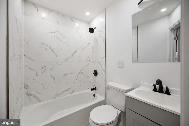 full bathroom featuring vanity, tiled shower / bath, and toilet