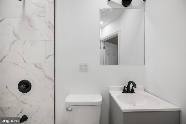 bathroom with vanity, toilet, and tiled shower