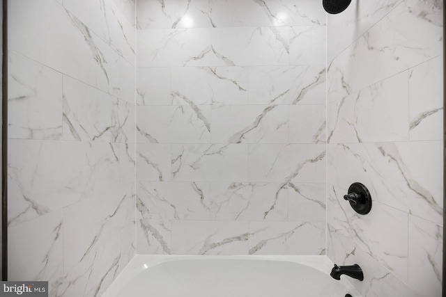 bathroom featuring tiled shower / bath