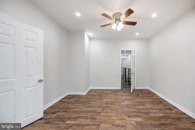 spare room with dark wood-type flooring and ceiling fan