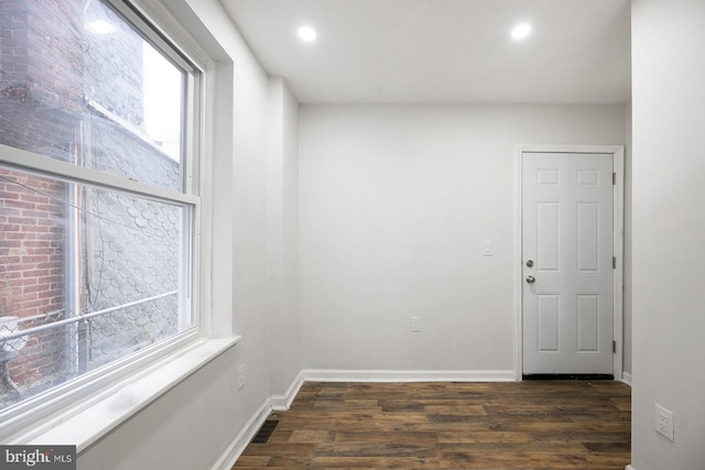 unfurnished room with dark hardwood / wood-style flooring