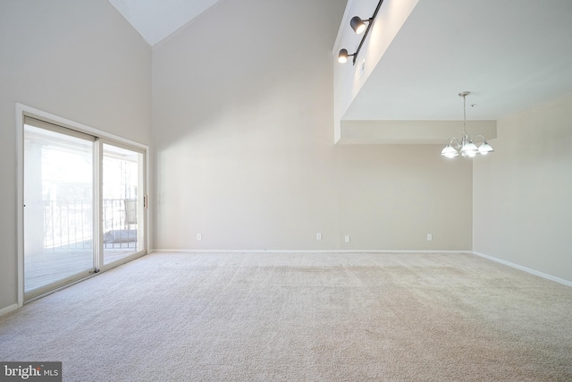 carpeted spare room with high vaulted ceiling and a notable chandelier