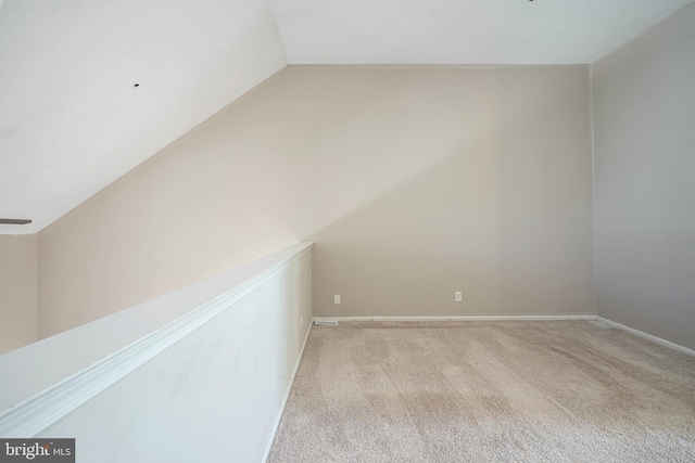 carpeted empty room with vaulted ceiling