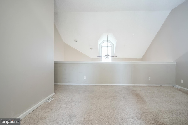 bonus room with light carpet and vaulted ceiling