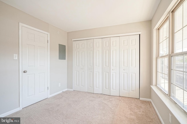 unfurnished bedroom featuring light colored carpet and a closet