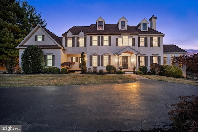 colonial inspired home with a lawn