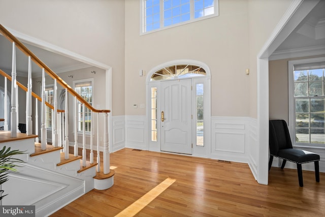 entryway featuring a wealth of natural light, hardwood / wood-style flooring, and crown molding