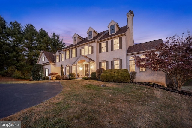 colonial home featuring a lawn