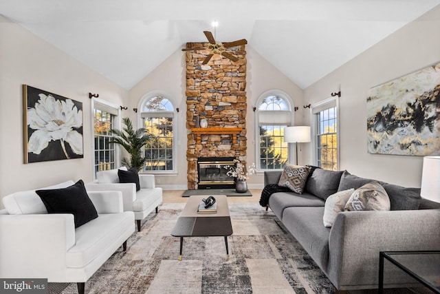 living room featuring a stone fireplace, high vaulted ceiling, hardwood / wood-style floors, and ceiling fan