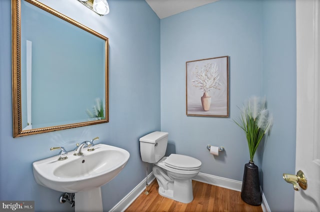 bathroom with hardwood / wood-style floors, sink, and toilet