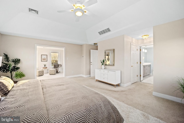 bedroom with vaulted ceiling, light colored carpet, ceiling fan, and ensuite bathroom