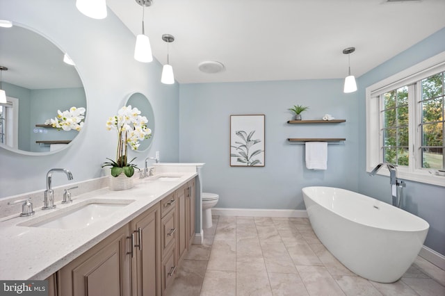 bathroom featuring toilet, vanity, a tub, and tile patterned floors